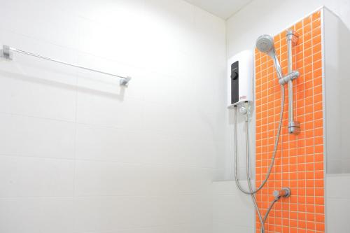 y baño blanco con ducha de azulejos de color naranja. en Pueanjai Resort and Restaurant, en Chumphon