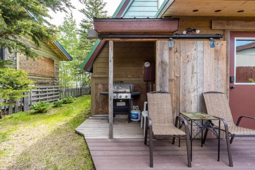 a cabin with two chairs and a table on a deck at Raven's Heart in West Yellowstone