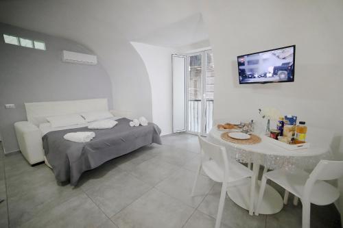 una camera con letto, tavolo e TV di casa sant’anna a Napoli