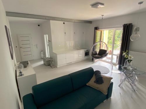 salon z zieloną kanapą i stołem w obiekcie PRZYTULNY APARTAMENT Z KOMINKIEM PRZY JEZIORZE w Bornem-Sulinowie