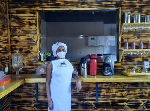 Una mujer parada en una cocina con una máscara en POUSADA ROTA DAS ÁGUAS en São Félix do Tocantins