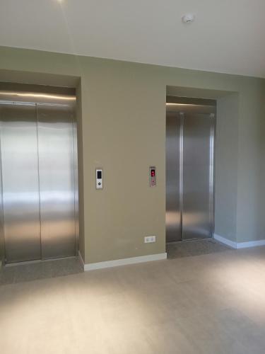 three elevators in a building with silver doors at New Twins 333 in Gudauri