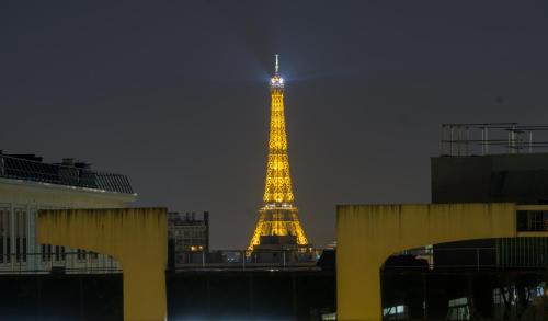 Blick auf den Eiffelturm in der Nacht in der Unterkunft EXIGEHOME Grand T2 proche Paris Porte d'Orléans in Châtillon