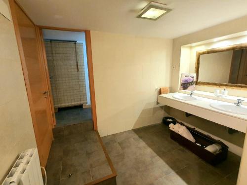 ein Bad mit einem Waschbecken und einem Spiegel in der Unterkunft El Refugio de El Escorial in San Lorenzo de El Escorial