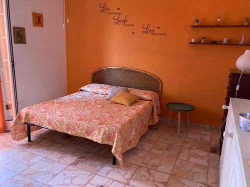 1 dormitorio con 1 cama con pared de color naranja en finestra tra cielo e mare, en Luni