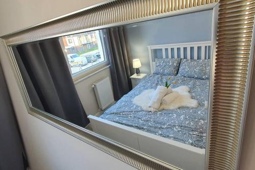 ein Spiegel, der ein Bett mit ausgestopftem Tier reflektiert in der Unterkunft Apartament3City in Danzig