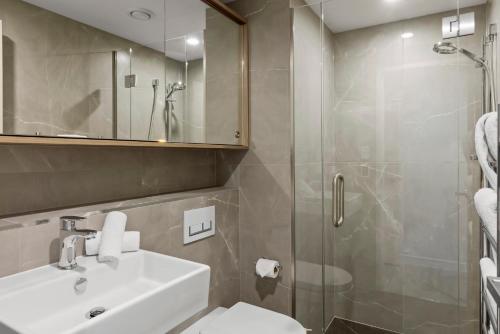y baño con lavabo y ducha. en Riverview Penthouse - Apartment 19 en Queenstown