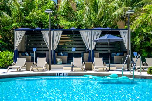 a pool with chairs and umbrellas in a resort at Anna Maria Beach Resort in Holmes Beach