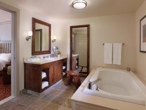 a bathroom with a tub, sink and mirror at Harvest Inn in St. Helena
