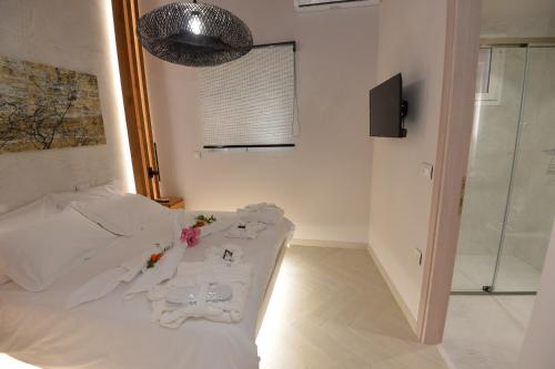 a bedroom with a bed with white sheets and flowers on it at Kameiros Treasure Villa in Kalavárda