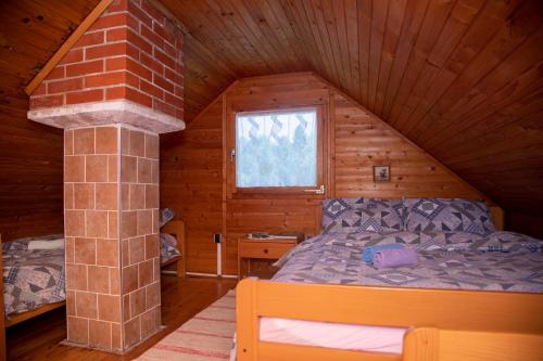 a bedroom with a bed in a log cabin at My dream house in Vrhovci