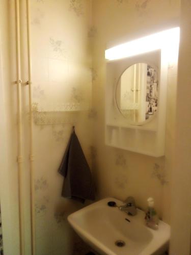 a bathroom with a sink and a mirror at Jokihelmi-apartment in Kannus