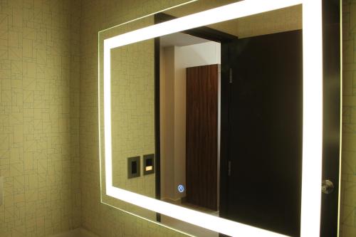 a mirror in a bathroom with lights on it at Holiday Inn Express - Monterrey - Fundidora by IHG in Monterrey