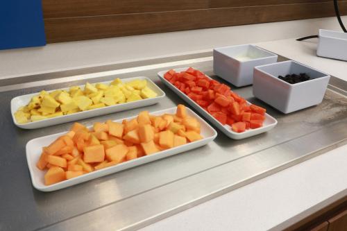 four trays of different types of fruits on a counter at Holiday Inn Express - Monterrey - Fundidora by IHG in Monterrey
