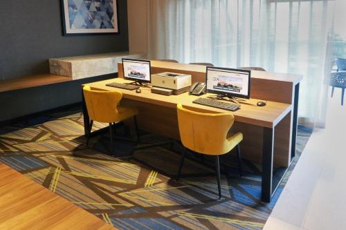 a desk with three computers on top of it at Holiday Inn Express - Monterrey - Fundidora by IHG in Monterrey