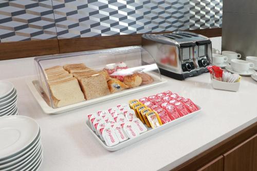 a table with two trays of food and a toaster at Holiday Inn Express - Monterrey - Fundidora by IHG in Monterrey