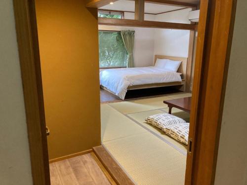 a room with a bedroom with a bed and a table at Koya TRIBE - Vacation STAY 83052v in Oishi
