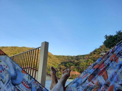 a person laying in a hammock with their feet up at Casa DeTe Caldas-Barbalha in Barbalha