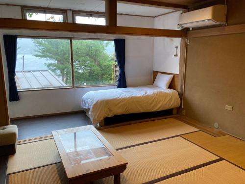 a small room with a bed and a table and a window at Koya TRIBE - Vacation STAY 81288v in Oishi