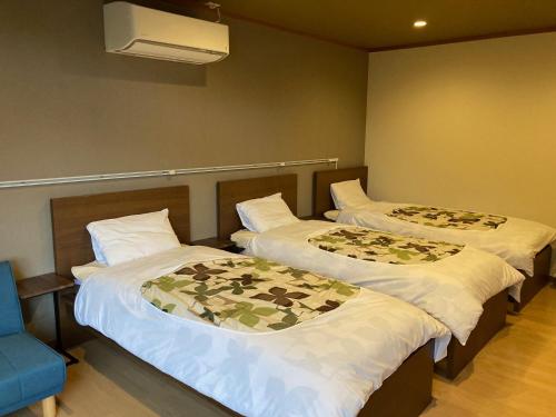 Duas camas num quarto com uma cadeira azul em Koya TRIBE - Vacation STAY 83398v em Oishi