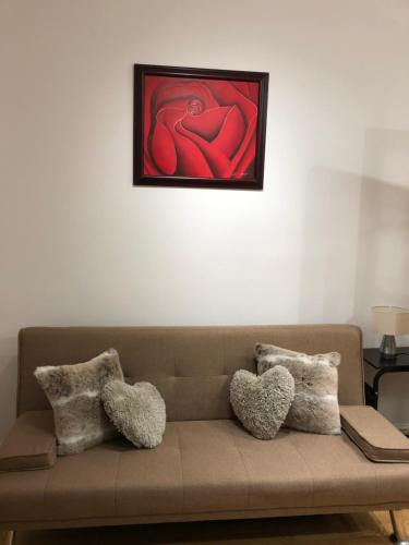 a living room with a couch with a painting on the wall at Modern Apartment in Twickenham Highstreet in Twickenham