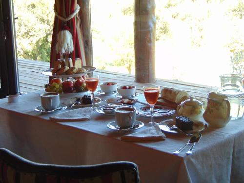 un tavolo con cibo e bevande in cima di Hostería Encanto del Lolog a San Martín de los Andes
