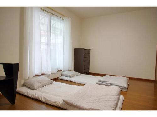 NYOZE House - Vacation STAY 84305v في طوكيو: سريرين في غرفة مع نافذة
