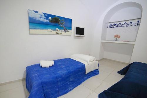 Cette chambre blanche dispose d'un lit bleu et d'une fenêtre. dans l'établissement Casa Carmela, à Naples