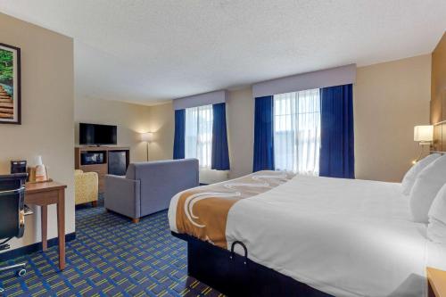 a hotel room with a large bed and a chair at Quality Inn in Lee