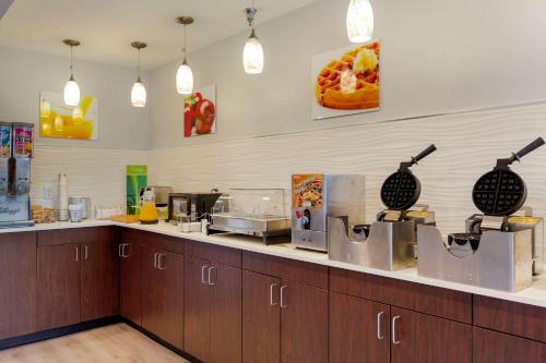 a kitchen with wooden cabinets and a counter at Quality Inn in Lee