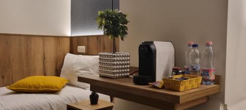 a bedroom with a bed with a table with bottles on it at Riverside Inn - dunaparti szuterén in Győr