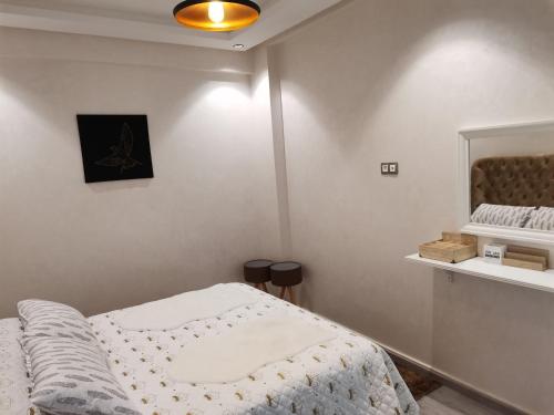 - une chambre avec un lit et une couette blanche dans l'établissement Central parc, à Mohammedia
