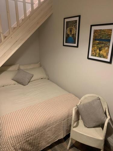 a small bedroom with a bed and a chair at The Carriage House in Matlock