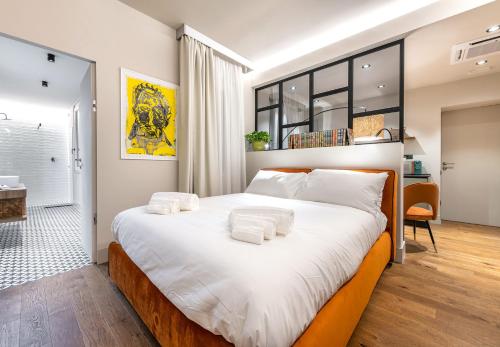 a bedroom with a large bed with towels on it at VicomilleSuites Cagliari Adult Only in Cagliari