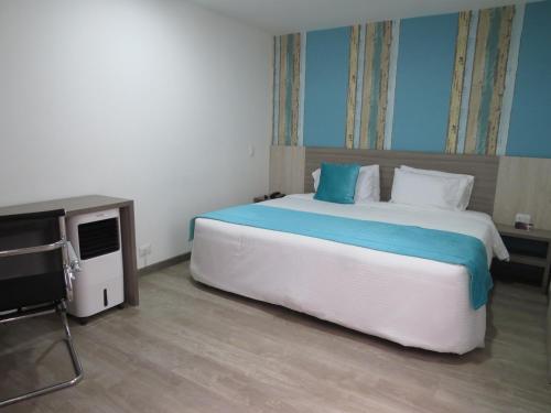 a bedroom with a large bed and a television at Hotel Los Cristales in Santa Rosa de Cabal