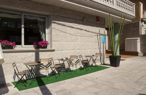 a group of chairs and tables in front of a building at Pontus Veteris in Sanxenxo