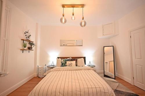 1 dormitorio con 1 cama grande y espejo en The Teapot Cottage in town centre FREE parking, en Stratford-upon-Avon