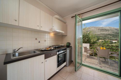 a kitchen with a sink and a sliding glass door at Minas Apartments in Divarata