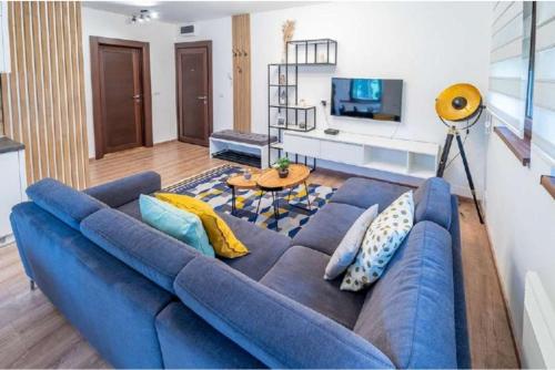 a living room with a blue couch and a table at Apartman Pavle in Zlatibor