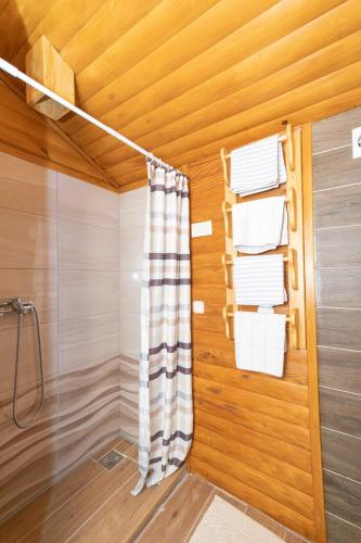 a bathroom with wooden walls and a shower with towels at Apartman Gomirje in Vrbovsko