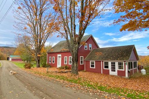 a red house on the side of a road at Vermont Mountain Farmhouse in Ludlow