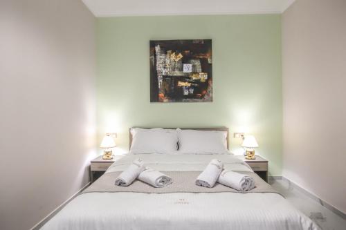 a bedroom with a large white bed with two lamps at Del Sol #2 Meteora Luxurious Family Suites in Kalabaka