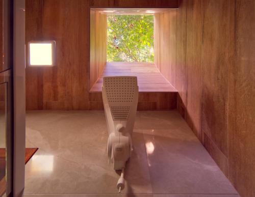 a chair in the middle of a room with a window at Verde da Mantiqueira Chalés in Visconde De Maua