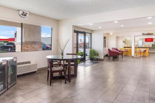 a lobby with a table and chairs in a building at Red Roof Inn Albuquerque - Midtown in Albuquerque