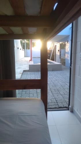 a view of a bedroom with a view of a patio at Balli Suítes in Ilha Comprida