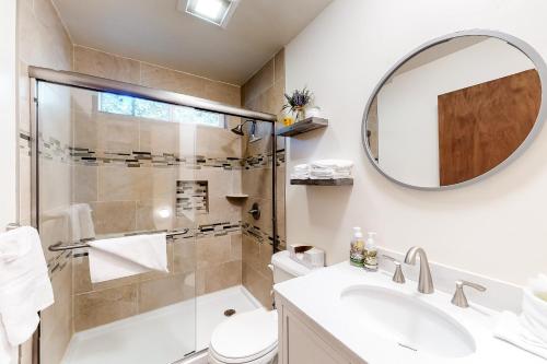 uma casa de banho com um chuveiro, um lavatório e um espelho. em Truckee Mountain Retreat em Truckee