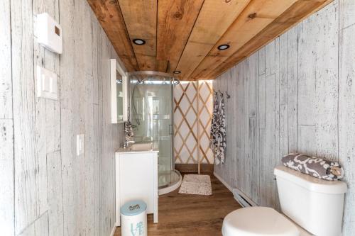 La salle de bains est pourvue de toilettes et d'un lavabo. dans l'établissement Yourtes Glamping du Poisson Blanc, à Notre-Dame-du-Laus