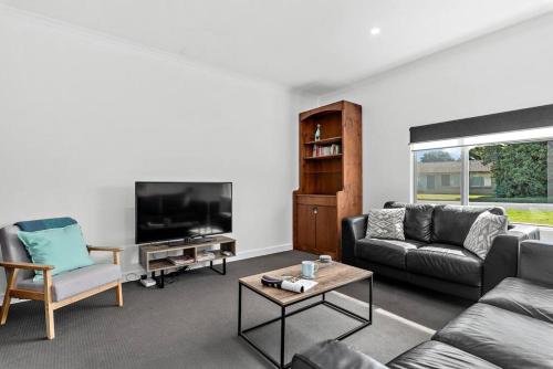 a living room with a couch and a tv at Kokomo - Silver Sands - C21 SouthCoast Holidays in Aldinga Beach