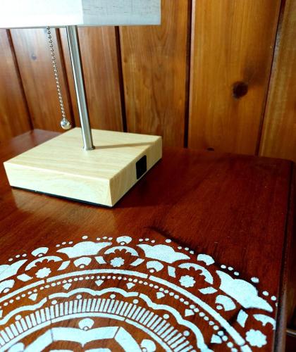 a wooden table with a lamp on top of a wooden floor at The Sunsetter Bed & Breakfast in Bocas del Toro