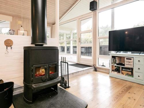 a living room with a fireplace and a tv at 8 person holiday home in Bl vand in Blåvand